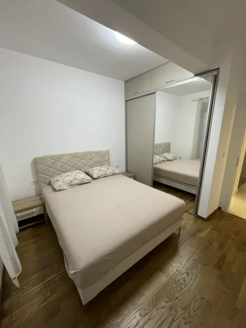 Bedroom with a double bed, nightstand, and fitted mirrored wardrobe.