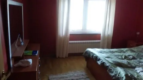 Spavaća soba sa crvenim zidovima, bračnim krevetom i prozorom. - image 6