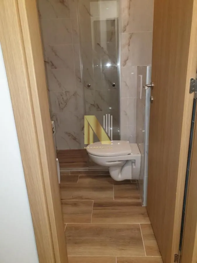 Pogled na kupatilo sa tuš kabinom i WC šoljom.
