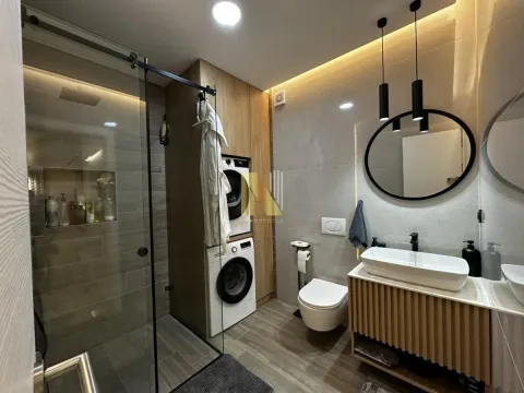 Moderno kupatilo sa tuš kabinom, umivaonikom i ugrađenom veš mašinom. - image 14