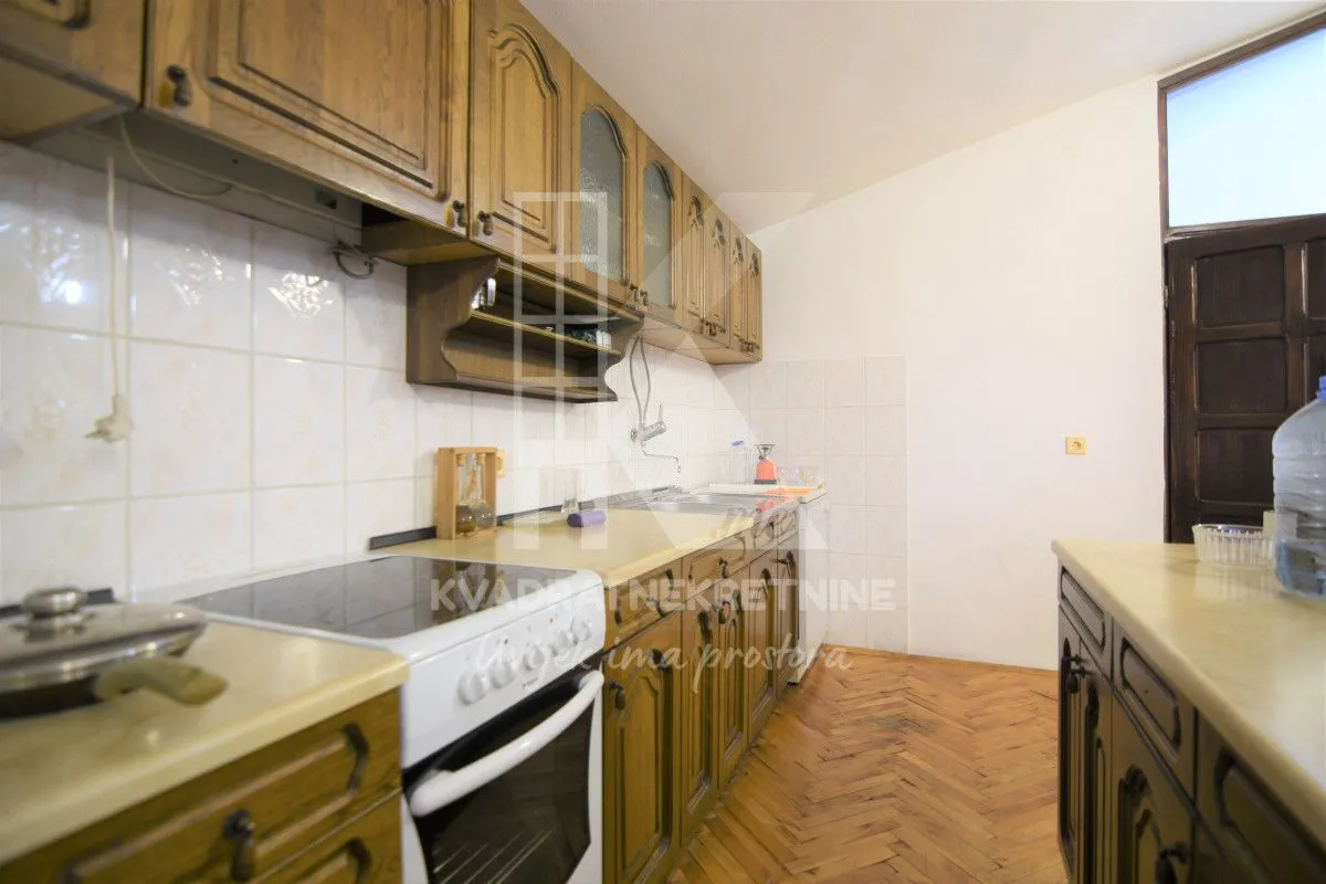 Kitchen with wooden cabinetry and parquet flooring.