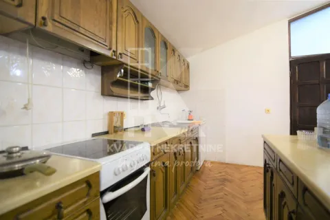 Kitchen with wooden cabinetry and parquet flooring. - image 4