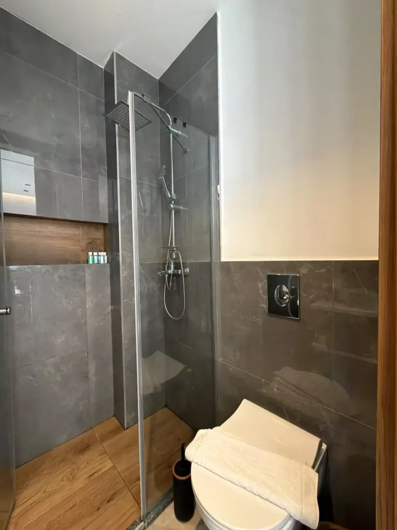 Moderne kupatilo sa tuš kabinom i ugradnom wc šoljom.