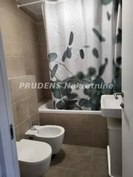 Kupatilo opremljeno sanitarijama, tuš kabinom sa zavesom i keramičkim pločicama u neutralnim tonovima. - image 13