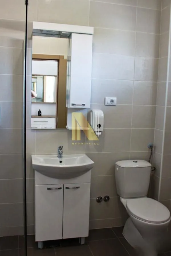Bathroom equipped with a sink vanity, mirror, and toilet.