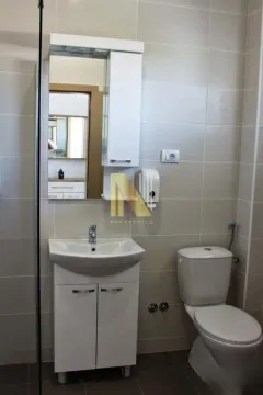 Bathroom equipped with a sink vanity, mirror, and toilet. - image 13