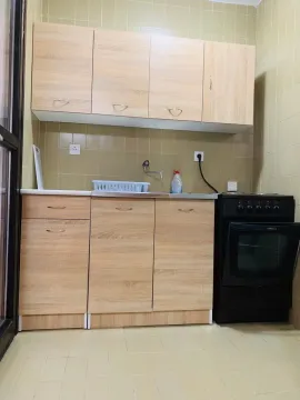 Manja kuhinja sa drvenim elementima i crnim šporetom. - image 3
