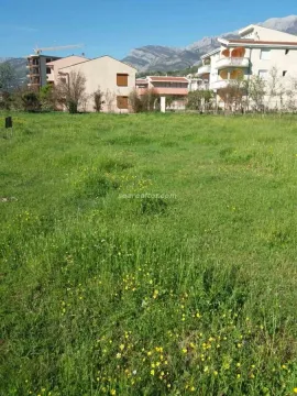 Zelena parcela sa pogledom na okolne zgrade i planine. - image 2