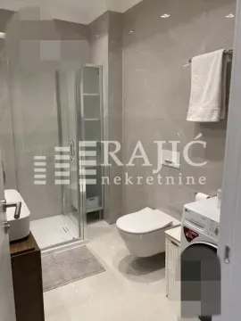 Modern bathroom with a walk-in shower and washing machine. - image 12