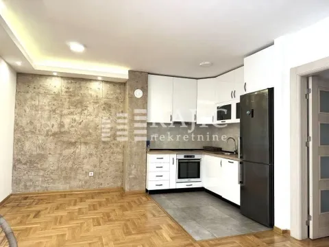 Modern kitchen with white units and a dining area. - image 2