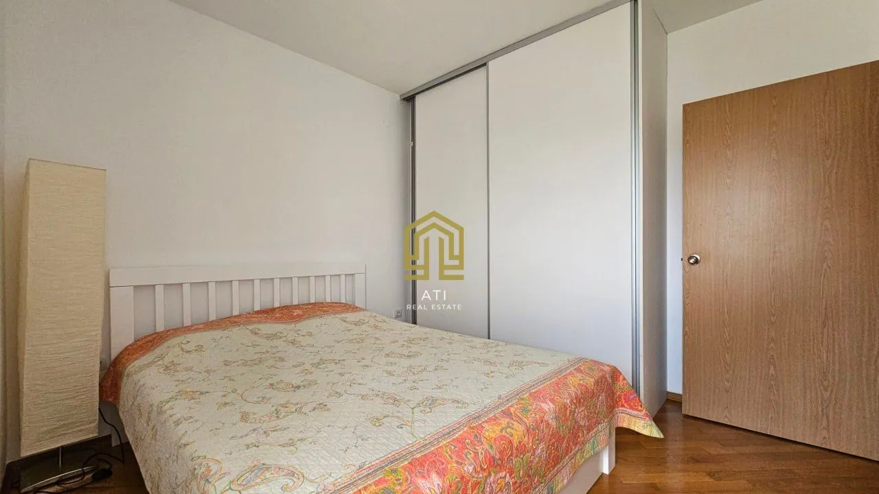 Bedroom with a double bed, large wardrobe, and wooden flooring.