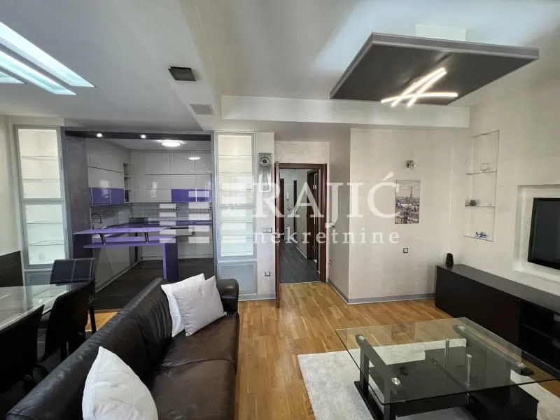 Living room with sofa and view of the kitchen.