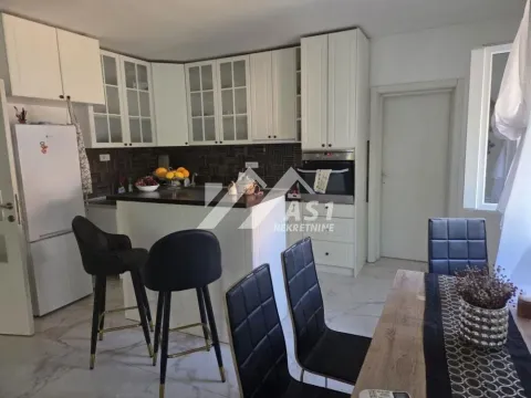 Kitchen with white cabinetry, a breakfast bar, and a dining area. - image 2