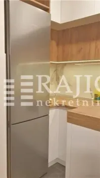 Moderna kuhinja sa ugradnim frižiderom i drvenim elementima. - image 3