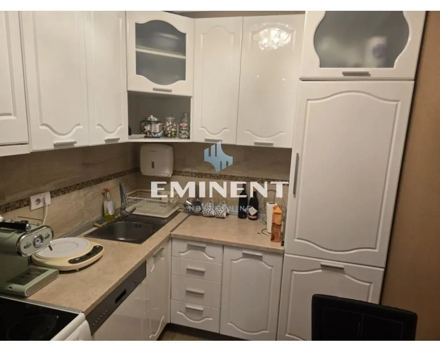 Small kitchen with white cabinets and a sink.