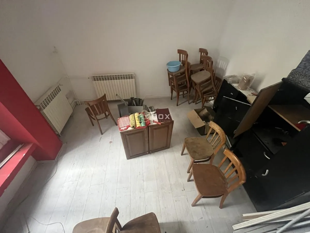 Empty room with wooden chairs and furniture being moved.