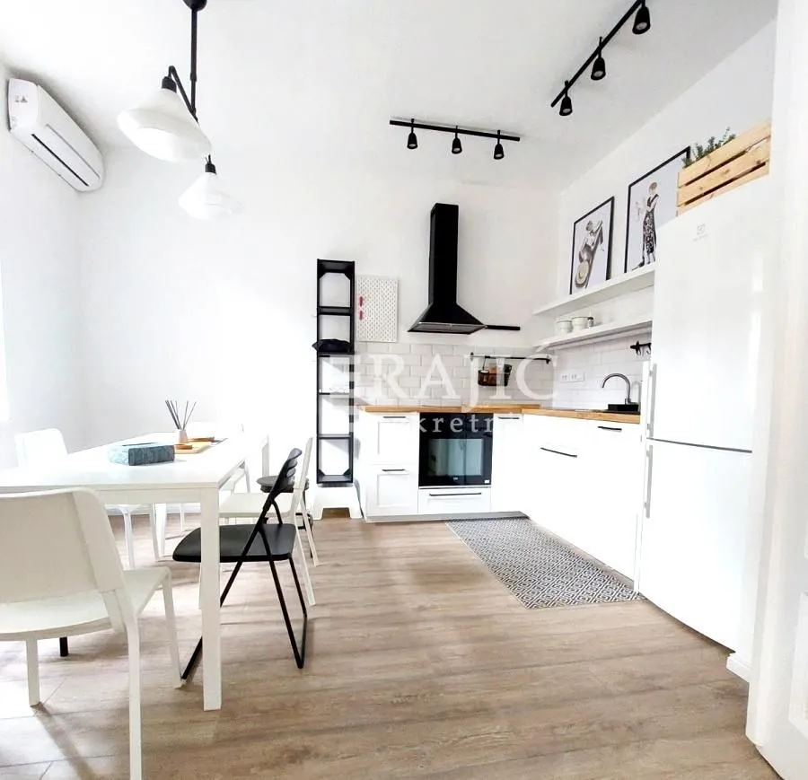 Modern white kitchen with a dining area and built-in appliances.
