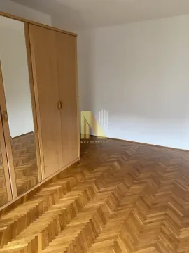 Spavaća soba sa drvenim ormarom i parketom na podu. - image 8