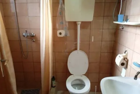 Manje kupatilo sa tuš kabinom, WC šoljom i umivaonikom obloženo keramičkim pločicama. - image 8