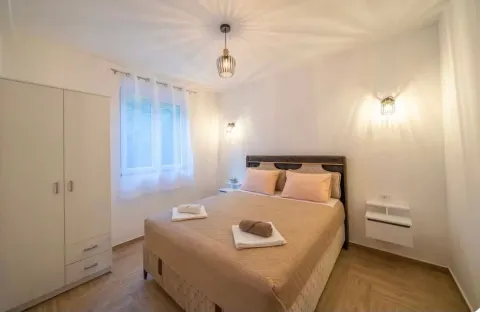Furnished bedroom with a double bed, wardrobe, and window. - image 2
