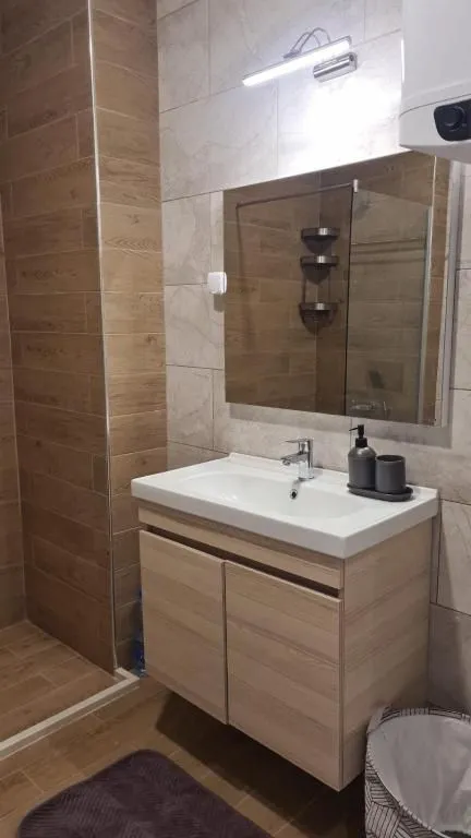 Modernly equipped bathroom with a washbasin, mirror, and shower cabin.