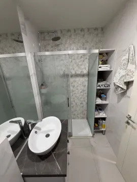 Moderne kupatilo sa tuš kabinom, umivaonikom i policama za odlaganje peškira. - image 14