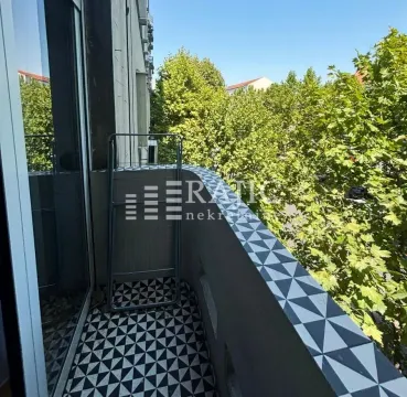 Small balcony with decorative tiles and a view of greenery. - image 13