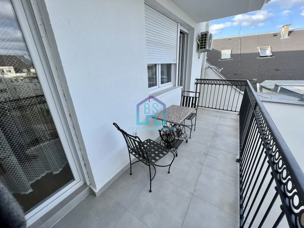 Furnished balcony with a table and chairs and metal railing.