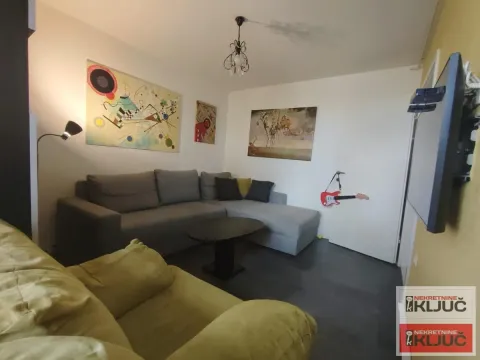 Dnevna soba sa garniturom za sedenje i slikama na zidu. - image 2