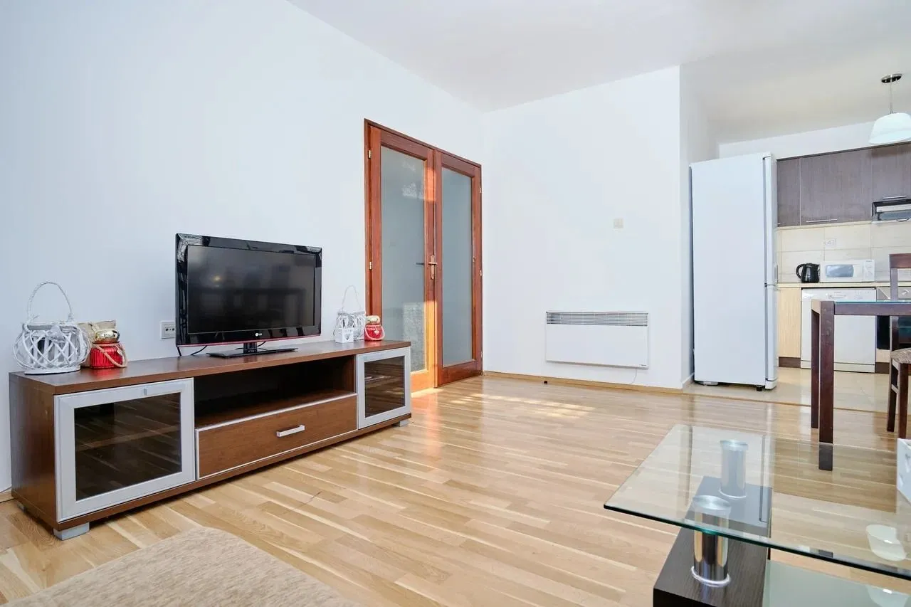 Spacious living room with wooden flooring and a television.
