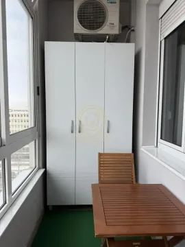 Zastakljeni balkon sa ormarom i malim drvenim stočićem. - image 16
