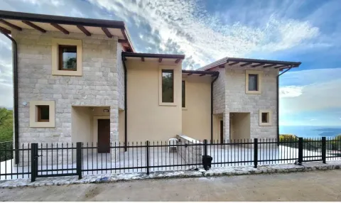 Pogled na spoljašnjost moderne kamene kuće sa dvorištem i ogradom. - image 2