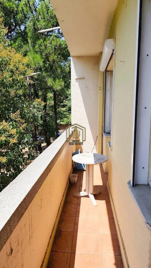 Furnished balcony with a view of greenery and surroundings.