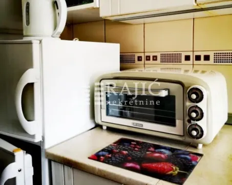 Part of the kitchen with a refrigerator, small oven, and kitchen units. - image 6