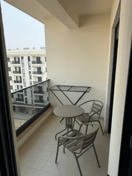 Covered balcony space with outdoor seating and a view of surrounding buildings. - image 11