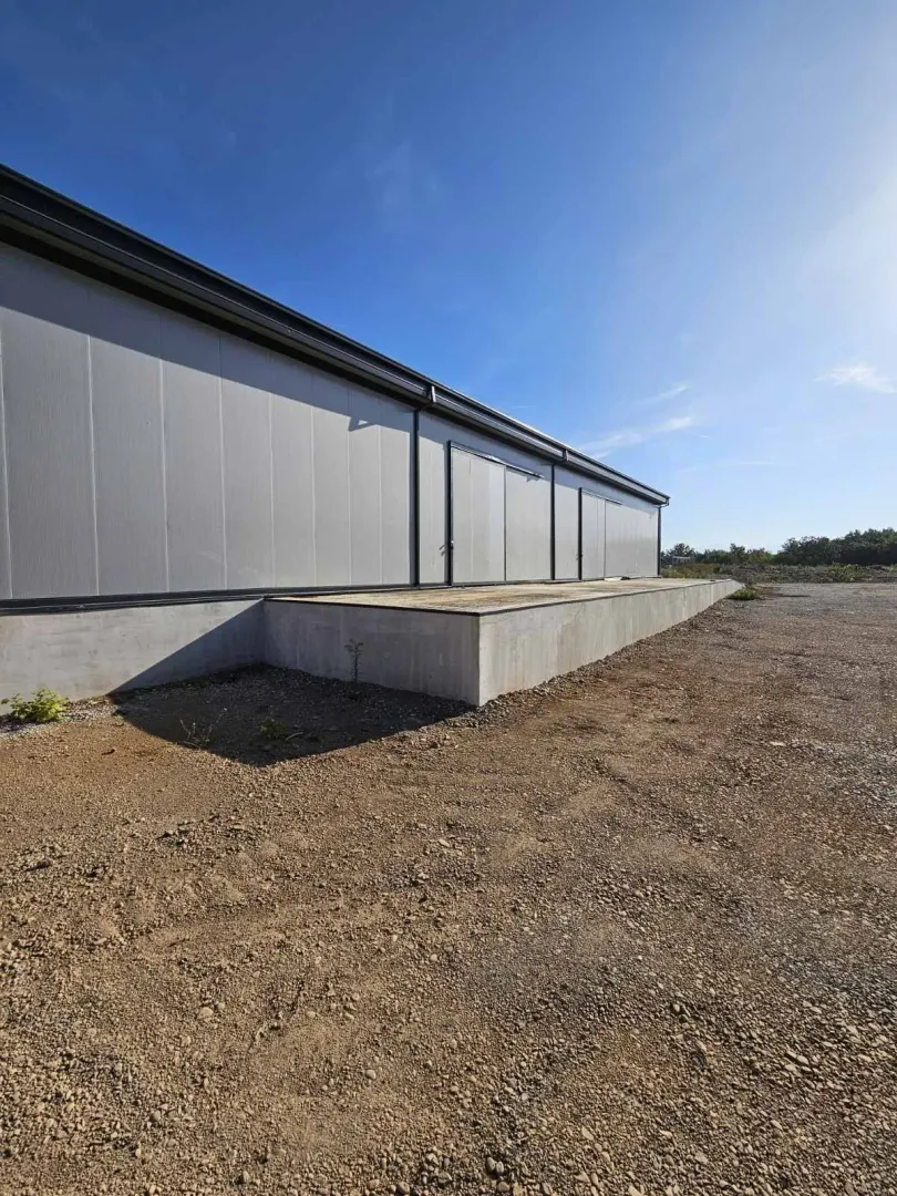 Exterior of an industrial building with a concrete ramp.
