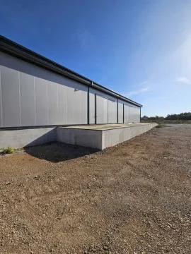Exterior of an industrial building with a concrete ramp. - image 13