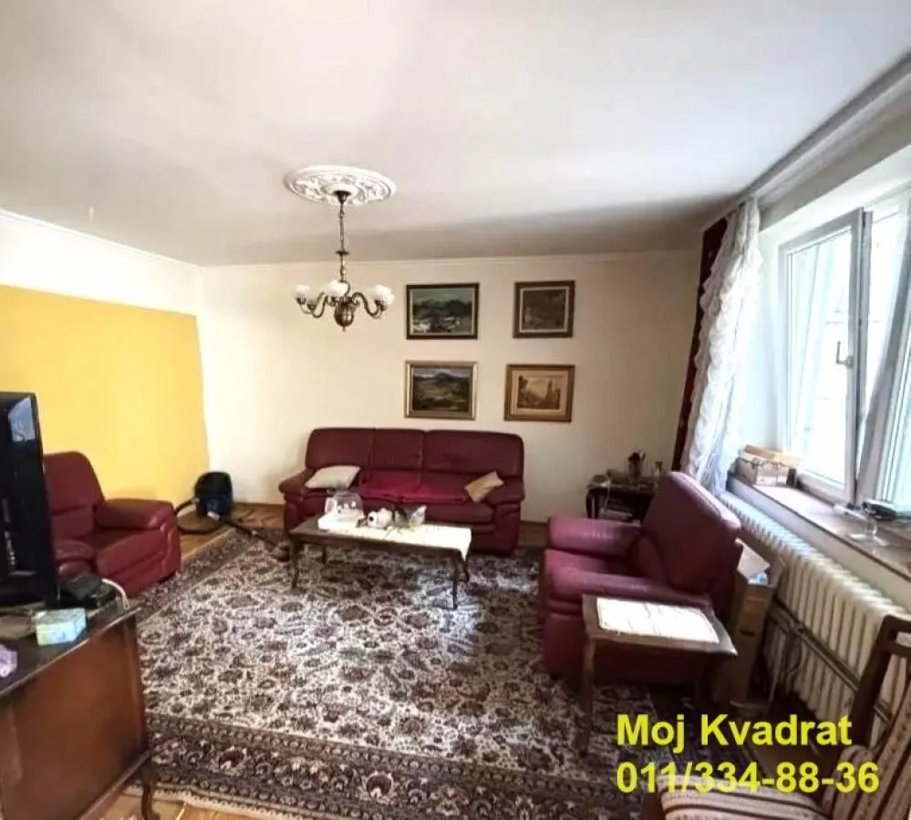 Dnevna soba sa garniturom za sedenje i prozorom.