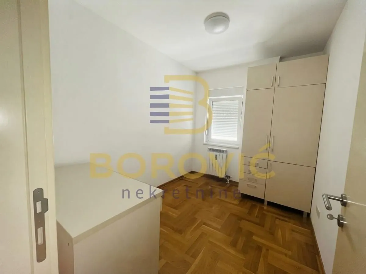 Smaller bedroom with a fitted wardrobe and parquet flooring.