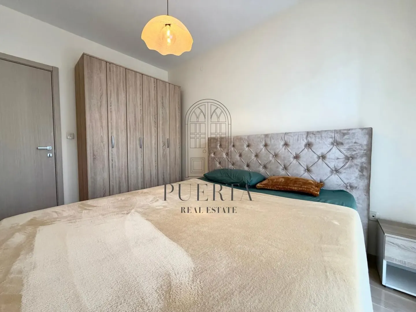 Furnished bedroom with a double bed and a fitted wardrobe.