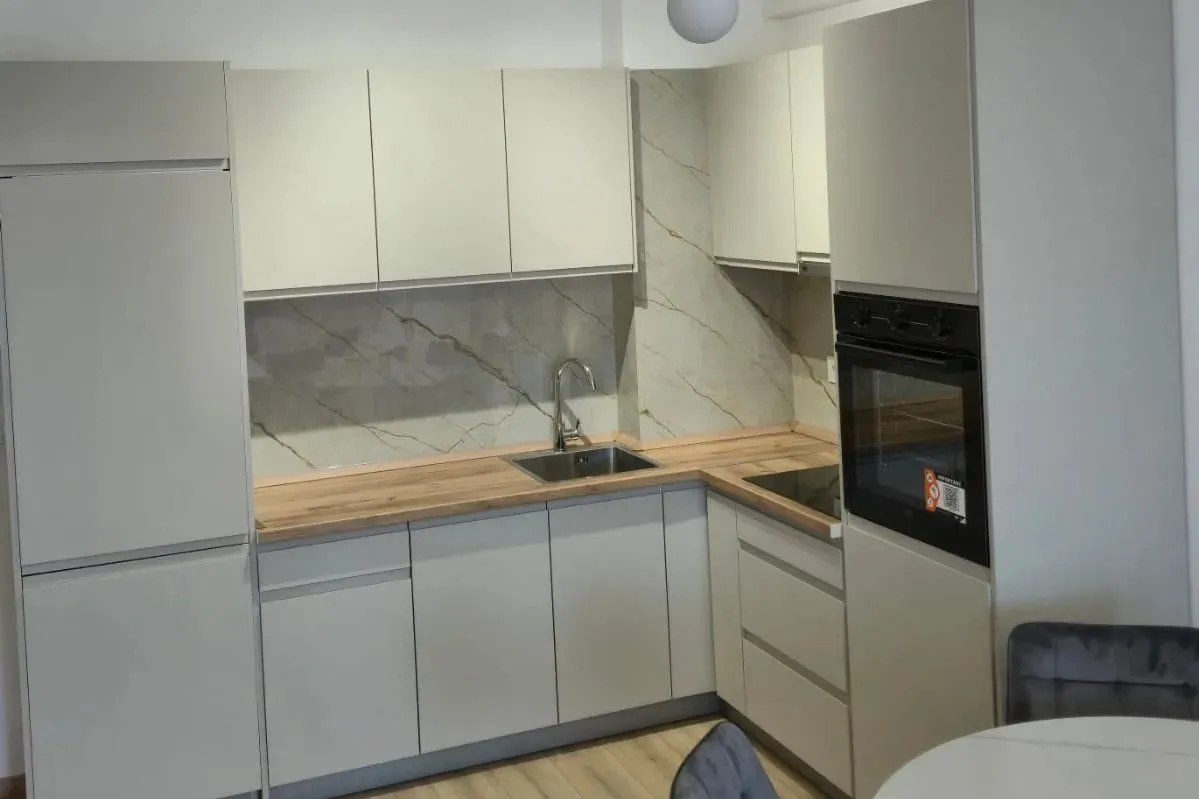 Modern kitchen with light cabinetry and built-in appliances.