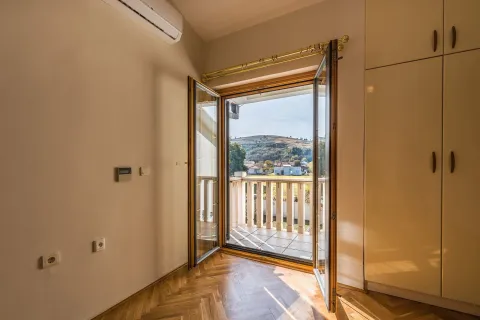 Bright room with balcony access and a scenic view. - image 15