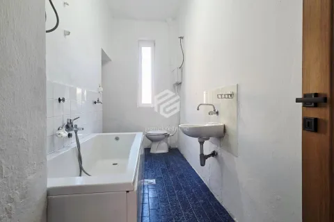 Smaller bathroom with a bathtub, washbasin, and toilet. - image 9