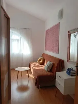 Manja dnevna soba sa kaučem, stočićem i prozorom sa zavjesama. - image 11