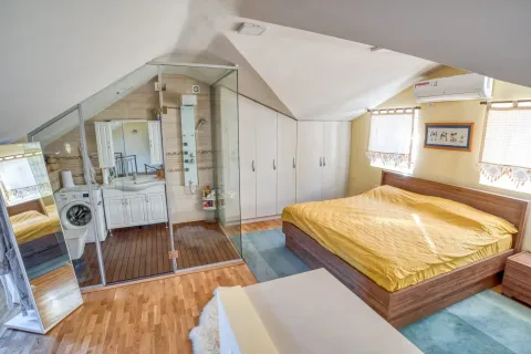 Spacious bedroom with a double bed, fitted wardrobes, and an open-plan bathroom with a shower cabin. - image 9