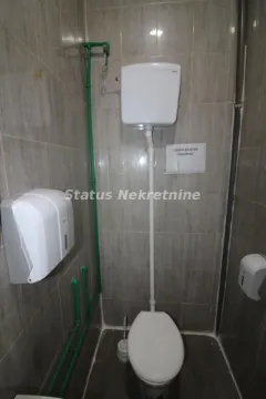 Small bathroom with a toilet and wall tiles. - image 11
