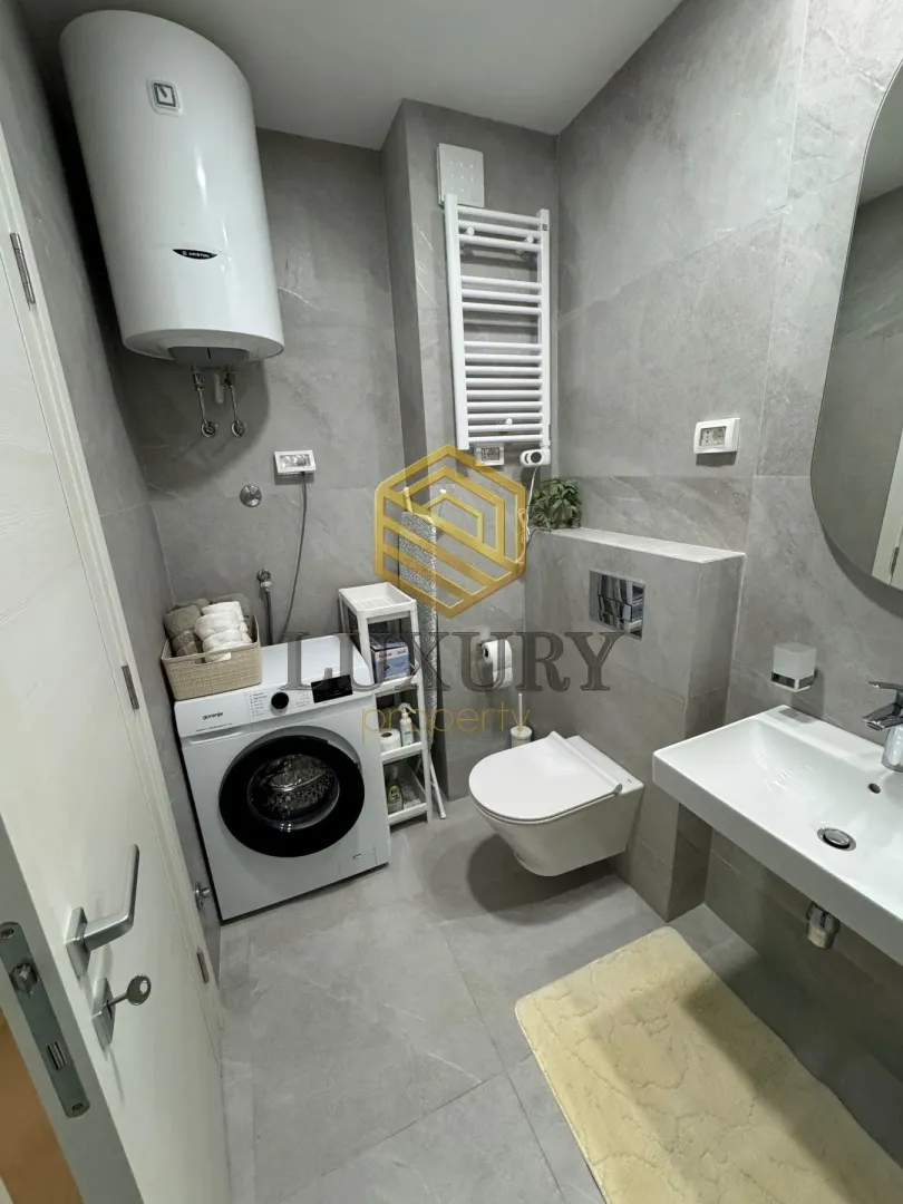 Modernly equipped bathroom with a washing machine and water heater.