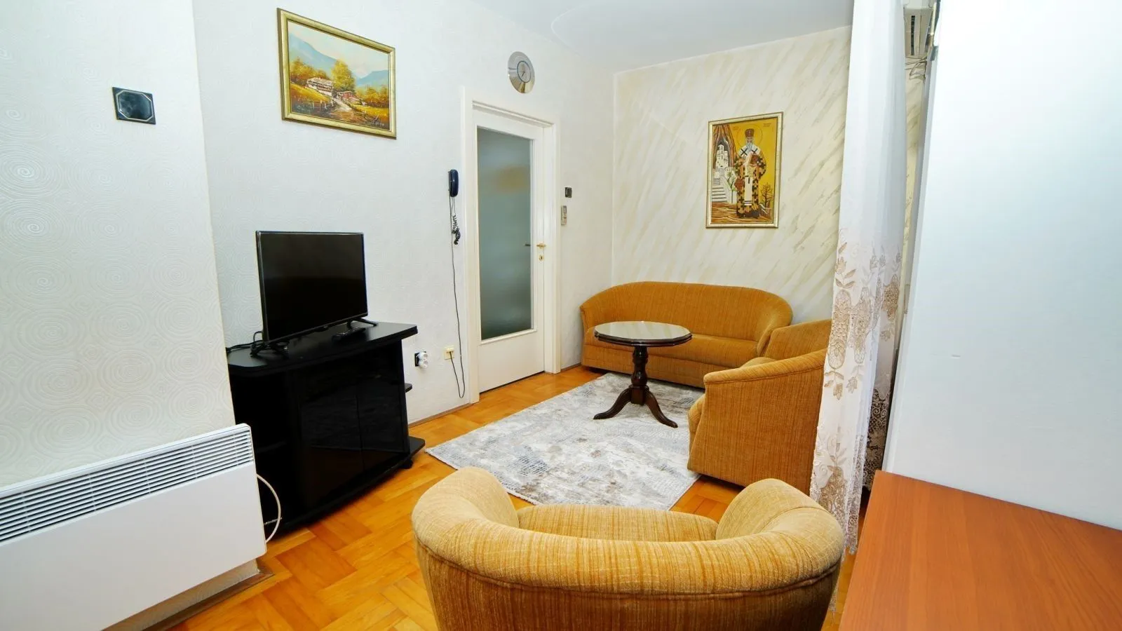 Simple living room with yellow furniture and a TV.