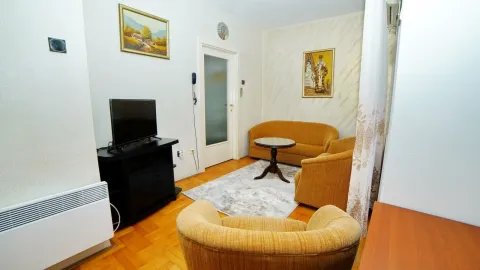 Simple living room with yellow furniture and a TV. - image 14