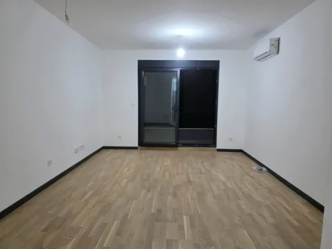 Prazna soba sa parketom, bijelim zidovima i klima uređajem. - image 3